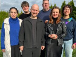 Auf dem Foto ist der neue Kreisvorstand zu sehen. Es sind sechs Personen abgebildet, die auf einer Wiese stehen, in die Kamera lächern und von der Sonne angestrahlt werden. Über ihnen ist der Himmel bewölkt und grau.
