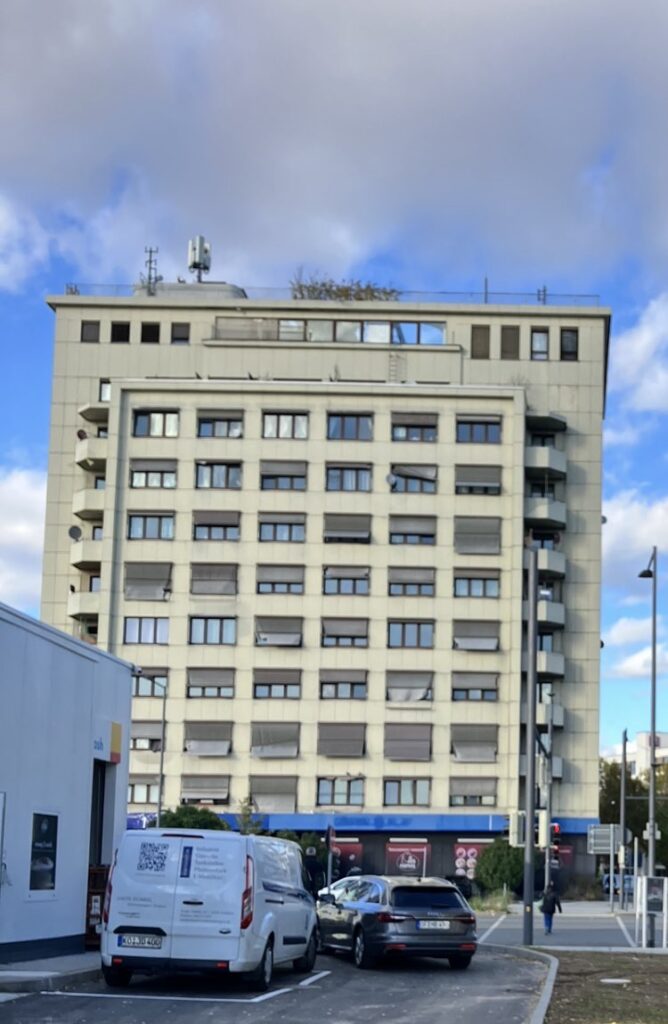 Auf dem Bild ist ein hohes und breites graues Wohnhaus abgebildet. Es handelt sich um das Wohnhaus in der Strahlenbergerstraße 123.